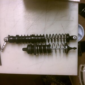 Rear HPI baja shock next to losi aftershock shock.