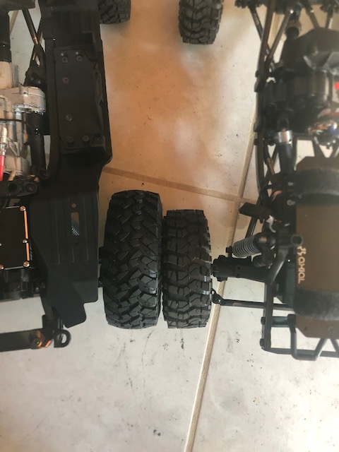 SCX10 original kit on right.  SCX10.3 on left.  Remarkable difference in stock tire size